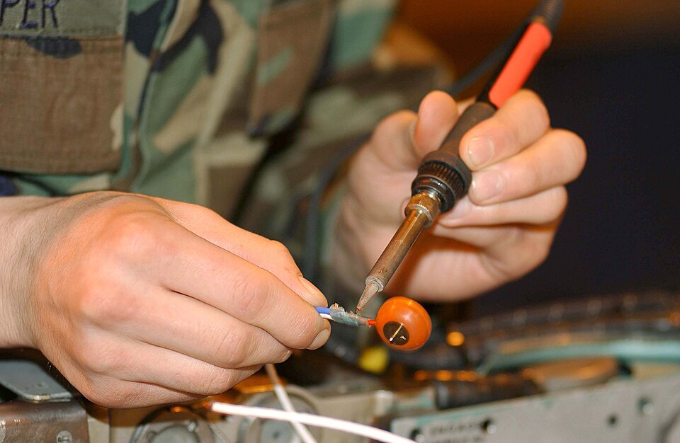 Technician soldering an electronic circuit board