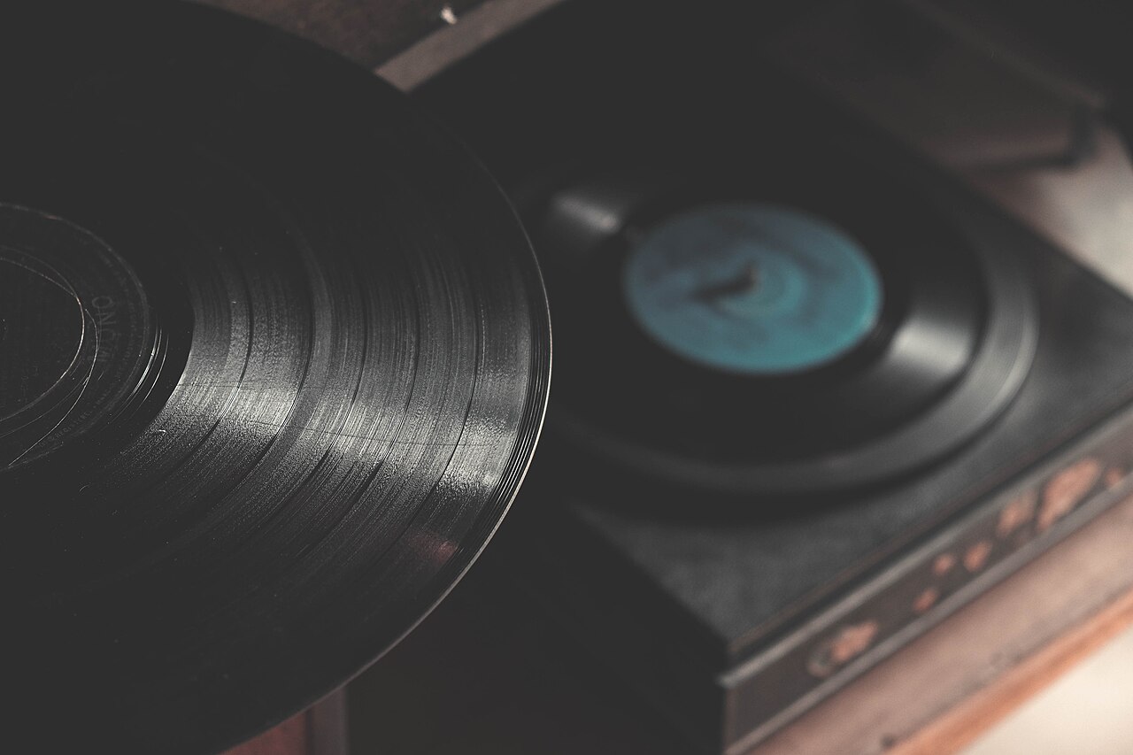 Vintage turntable with a vinyl record in a wooden plinth